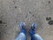 Person leg foot shoe on pavement road asphalt street. Outdoor road with jean man urban walk way concept. Sneaker standing on