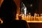 Person lighting a candle in a church with a blurry background