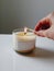 Person Lighting Candle on Table