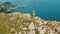 A person looks out over the sea of Capri. Elevated on the rocky outcrop, the lone figure contemplates the tranquil water