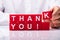 Person Making Thank You Text With Red Cubic Blocks