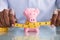 Person Measuring Pink Piggybank With Measure Tape