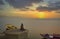 A person is meditating on the bank of river ganga on the ghats of varanasi while sun is rising