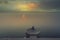 A person is meditating on the bank of river ganga on the ghats of varanasi while sun is rising