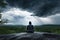 person, meditating, with storm brewing in the background