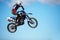 Person, motorcycle and air jump stunt as professional in action danger, competition or fearless in sky. Bike rider, off