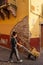 person moving fruit in a freight cart, behind an old building, regional, mexico