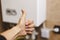 Person near central heating with thumb raised in gratitude