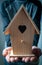 Person offering bird house in hands , buying house concept
