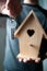 Person offering key to  bird house in hands , buying house concept