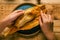 Person opening a tamale with his hands.