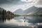 person, paddleboarding along serene lake, with mountain views in the background