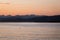 A person paddleboarding at sunset near Locarno Beach, Vancouver, Canada.