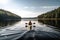 person, paddling kayak on calm lake, with view of the peaceful scenery