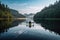 person, paddling kayak on calm lake, with view of the peaceful scenery