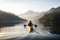 person, paddling kayak through calm lake, with view of the surrounding mountains visible in the background