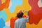 A person painting a feature wall in a creative pattern