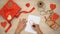 Person painting heart sign on paper, hand-made gift boxes on wooden background