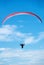 Person, parachute and paragliding in blue sky in air, nature for exercise with healthy adventure for extreme sport