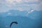 Person paragliding over alpine landscape with panoramic view of majestic mountain range Julian Alps seen from Gerlitzen Alpe