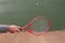 Person playing wall tennis hitting a tennis ball with tennis racket