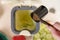 Person pouring bokashi ferment in a compost container on the table. Female recycling organic food leftovers in a composter bin