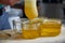 Person pouring and filtering a natural honey in a glass bowls