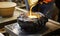 A Person Pouring Ingredients Into a Bowl on a Table