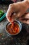 Person pouring Red hot chilli pepper sauce in a bowl in an Indian household Kitchen. India