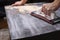 Person prepares the surface for painting and sanding by hands an old wooden black table