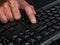 A person pressing the enter key on a black keyboard