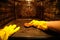 A person in protective gloves washes the dirty oven from traces of food inside with the light on