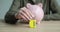 Person puts combination lock and piggy bank