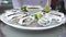 Person puts plate with tasty oysters on metal countertop