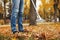 Person raking dry leaves outdoors on autumn day