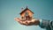 A person, a real estate agent, carefully holds a small model house in their cupped hands, symbolizing mortgage, rent, and real