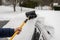 Person removes snow from car. Winter snow storm.