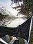 A person resting in a hammock by a lake surrounded by beautiful snow-covered mountains