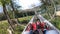 Person rides in fast rodelbahn sledding in mountains in woods among trees