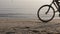 Person riding bicycle and traveling on beach near sea , cropped view