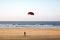 Person riding a kite board or mountain boarding on an empty sandy beach an exciting extreme sport with a kite