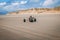 Person riding a kite buggy in a desert wearing a protective helmet