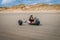 Person riding a kite buggy in a desert wearing a protective helmet