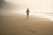 a person running on a beach in the foggy day with footprints in the sand and footprints in the sand and a person walking on the