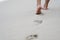 A person`s footprint while walking along the white beach