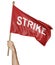 Person`s hand holding a waving flag with the word strike