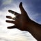 Person\'s Hand Reaching Towards Heaven Sunlight