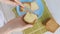 A person's hands delicately spreading butter on a piece of freshly sliced bread,