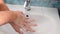 A person`s hands are washed in the sink with foam