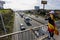 Person with the scarf and the national flag of Spain recording with the mobile the passage of the slow march of trucks protesting